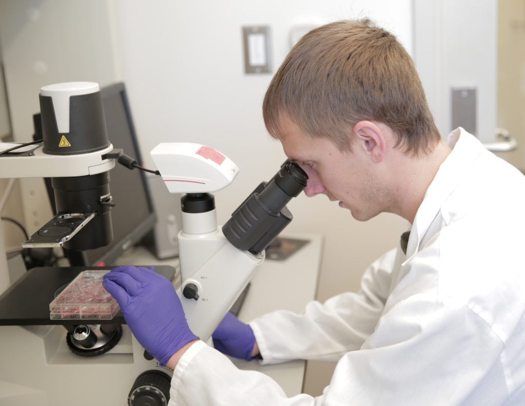 Photo of biomedical engineering graduate student Jared Carlson-Stevermer observes real-time CRISPR/Cas9 gene editing