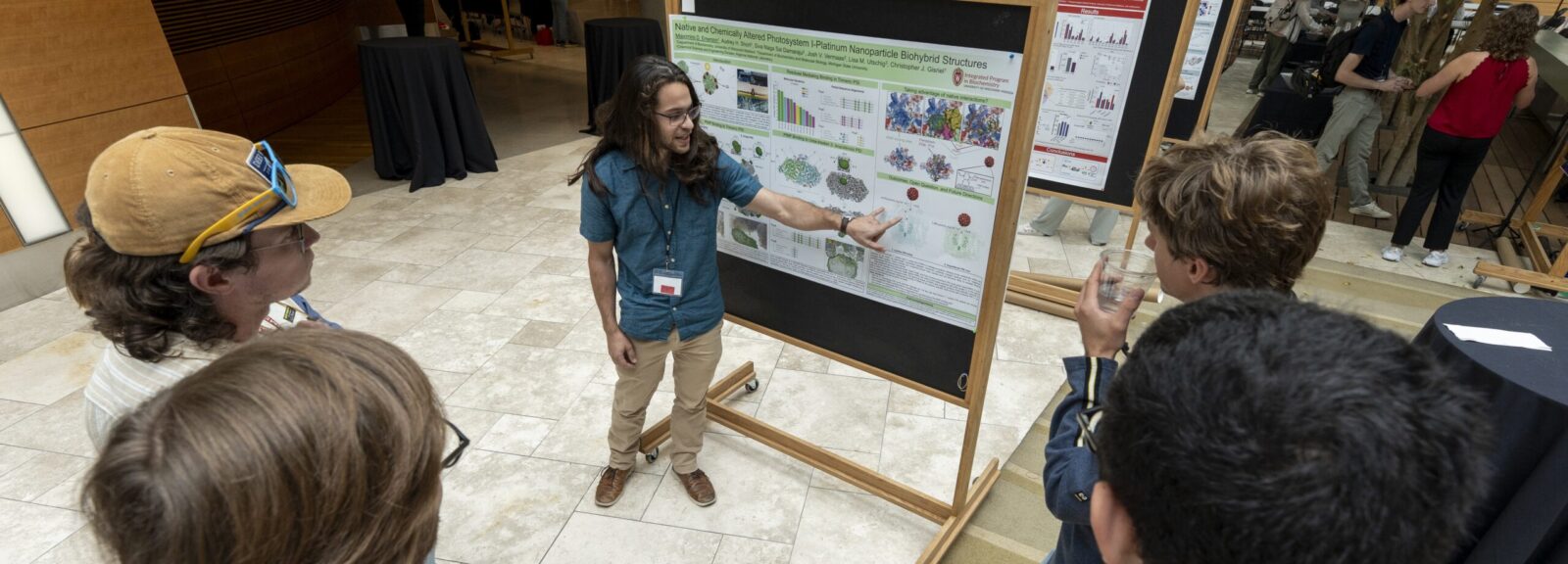 Max Emerson shares research at poster session with other graduate students.